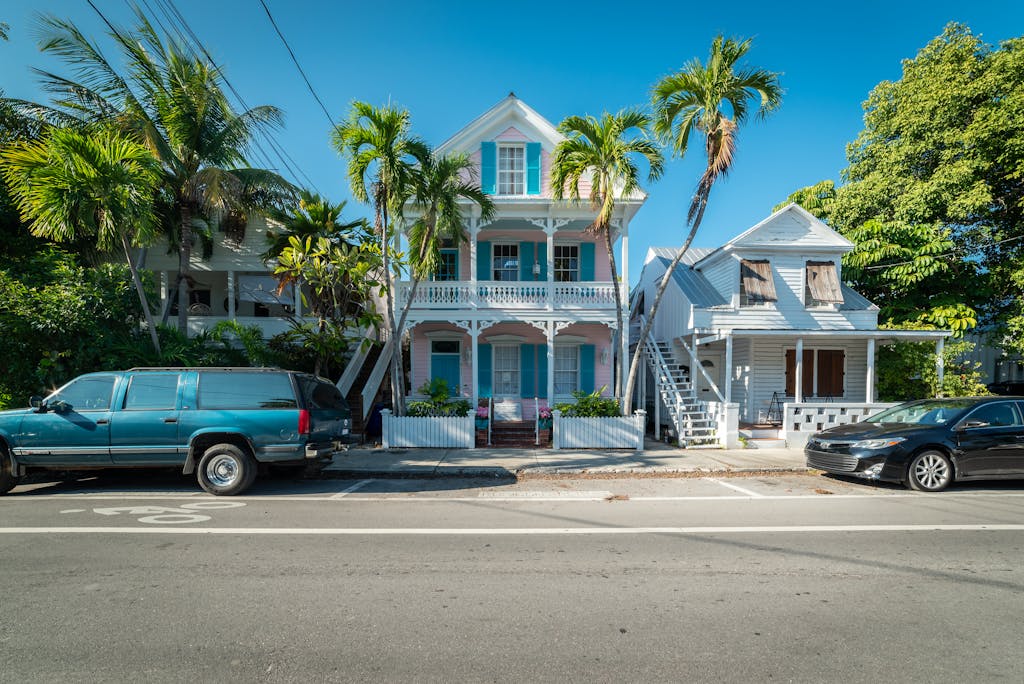 Colorful historic houses with palm trees along a sunny street in Key West, Florida.